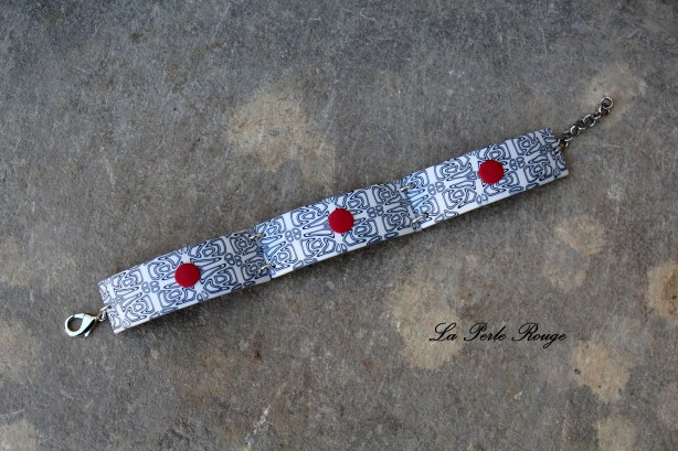Bracelet noir et blanc et ses pitites pastilles rouges. 